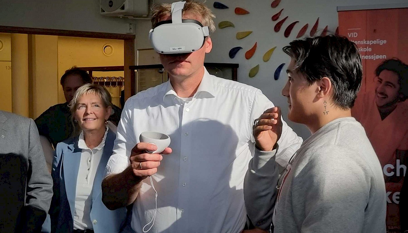 Student Milad Hashemi demonstrerer VR-teknologi som simuleringsverktøy for statsråd Ola Borten Moe. I bakgrunn Ordfører Herøy kommune Elbjørg Larsen. Foto: Helgelandssykehuset HF.